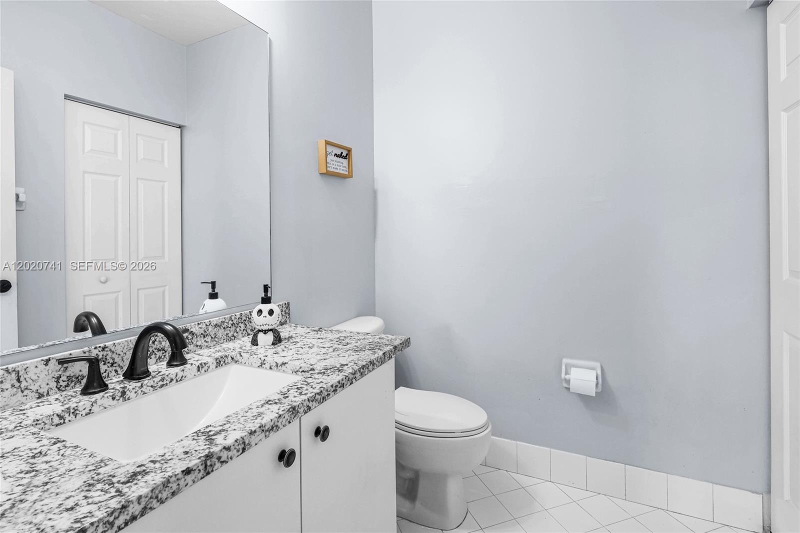 A bathroom features a granite vanity countertop, white cabinets, a toilet, and light-colored walls — 1595 NE 33rd Rd # 3, Homestead FL 33033, HOMESTEAD, FL