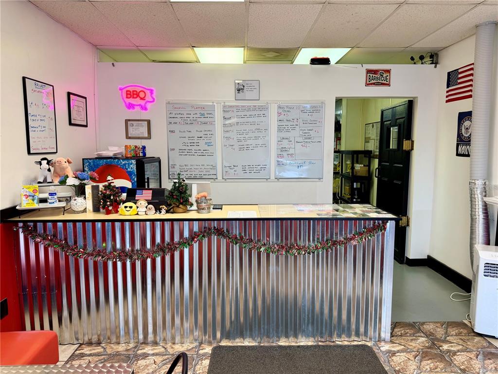 A barbecue restaurant interior features a corrugated metal service counter and menu boards on the wall — 12149 S WILLIAMS STREET UNIT 3, DUNNELLON, FL