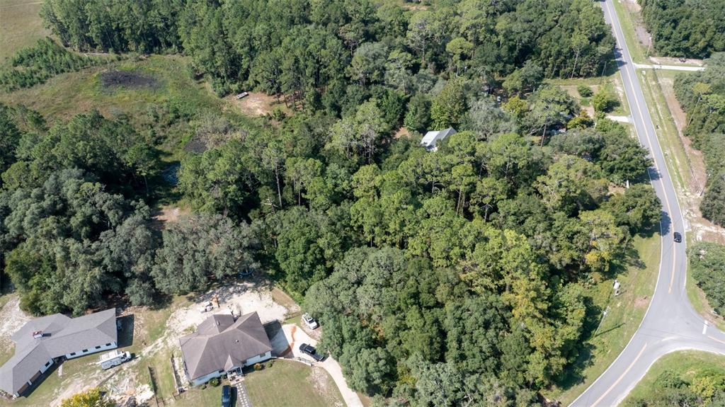 An aerial view shows a house with a large yard surrounded by dense forest — 101 ASHLEY LAKE DRIVE, MELROSE, FL