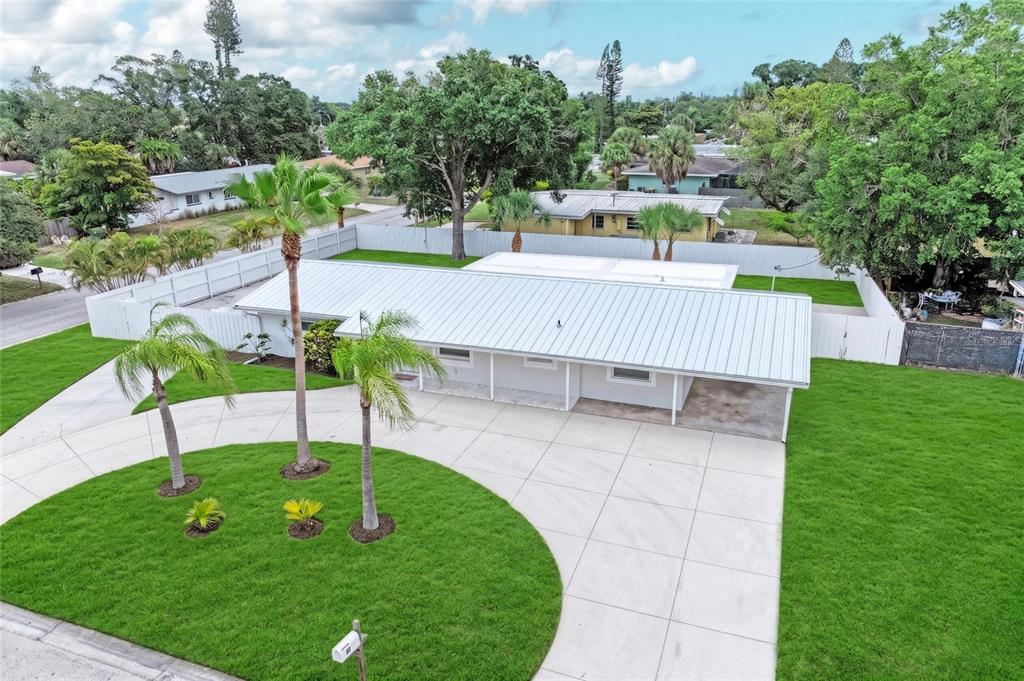 An aerial view of a single-story house with a metal roof and a concrete driveway — 2714 DATURA STREET, SARASOTA, FL