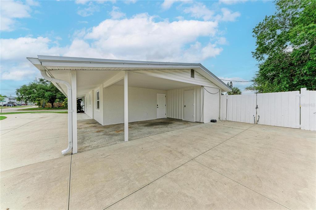 A concrete driveway leads to a covered carport attached to the side of a house — 2714 DATURA STREET, SARASOTA, FL
