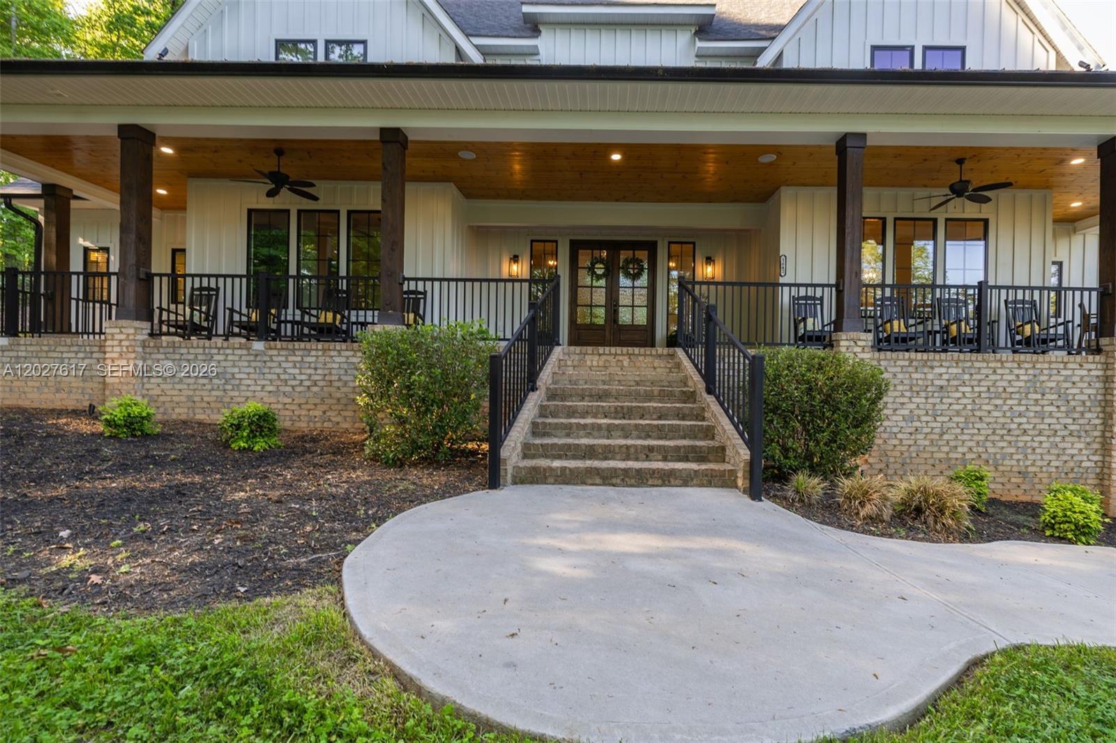 A front view of a house with a large covered porch, brick base, and stairs — 1642 Pineview Road, NC 27317, NC