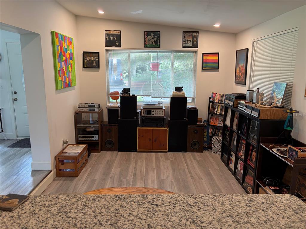 A living room features vinyl record storage, audio equipment, and framed music-themed wall art — 1115 NE 5TH PLACE, GAINESVILLE, FL