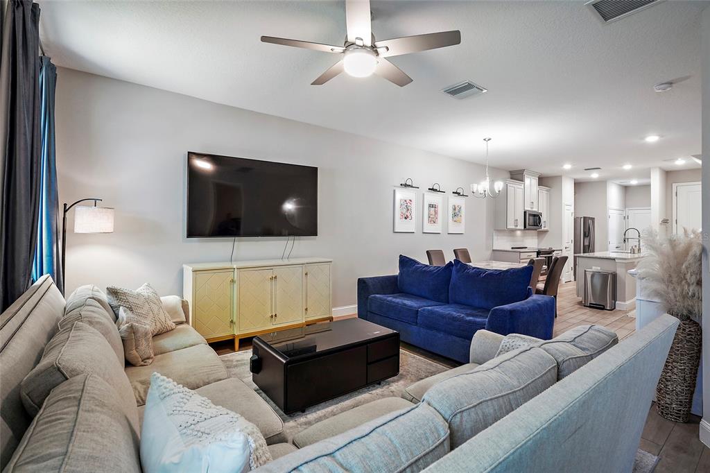 A living room features a large sectional sofa, a blue couch, and an open kitchen — 5246 NEIL DRIVE, ST PETERSBURG, FL