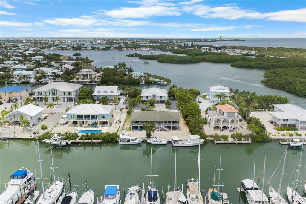 An aerial view shows waterfront houses with private docks along a canal near mangroves — 2100 AVENUE H, MARATHON, FL