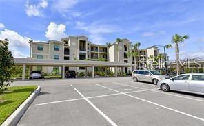 A multi-story apartment building with a covered parking area in front — 17510 GAWTHROP DRIVE UNIT 208, BRADENTON, FL