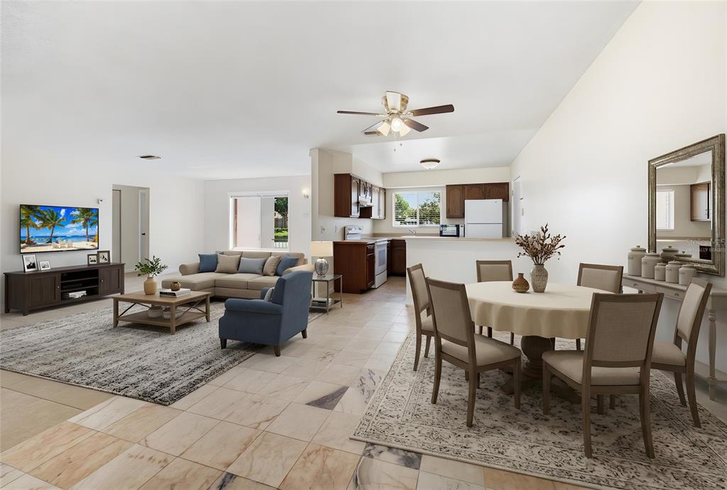 An open-concept living and dining area with tile flooring, a kitchen, and neutral furnishings — 10330 GALLIARD BOULEVARD, ORLANDO, FL