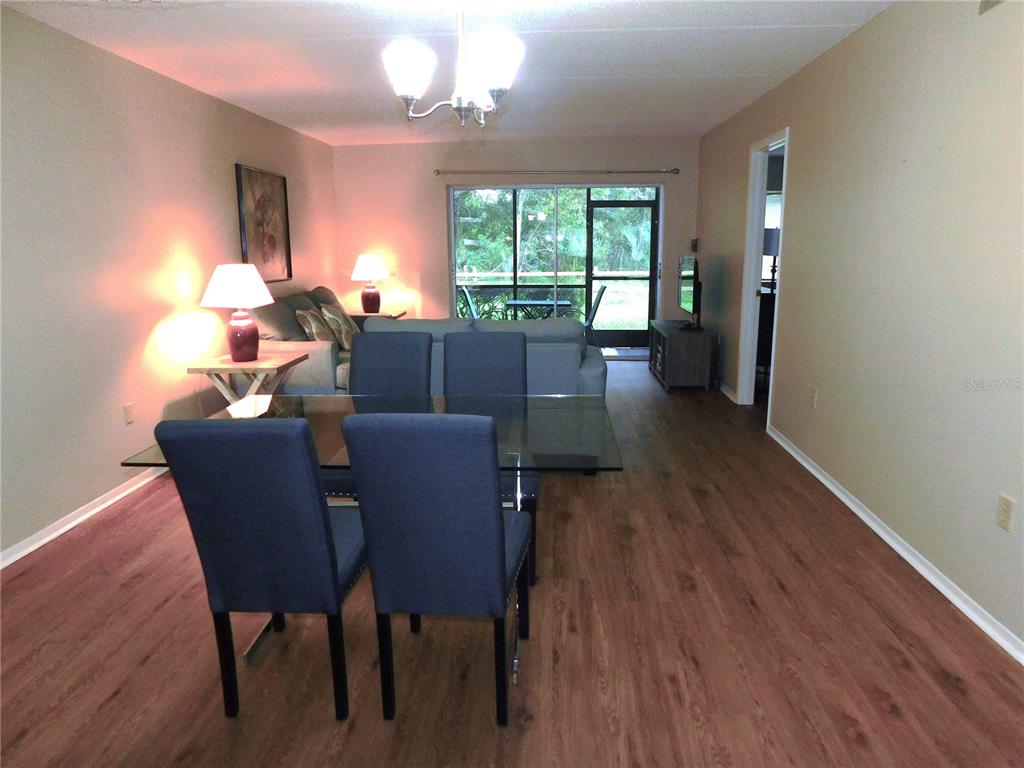 A dining area features a glass table, four blue chairs, and a kitchen pass-through window — 105 PALMETTO COURT, OLDSMAR, FL