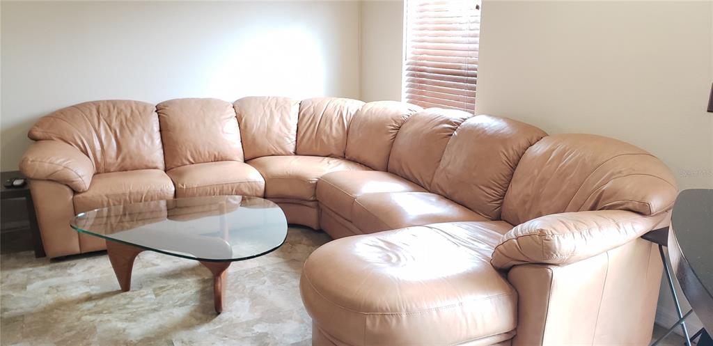 A tan leather sectional sofa sits on a tiled floor in a living room — 4560 ASHBURN SQUARE DRIVE, TAMPA, FL