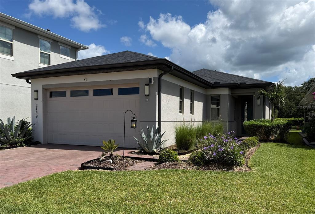 A single-story house with a two-car garage, stucco exterior, and landscaped front yard — 3149 SONGBIRD CIRCLE, ST CLOUD, FL