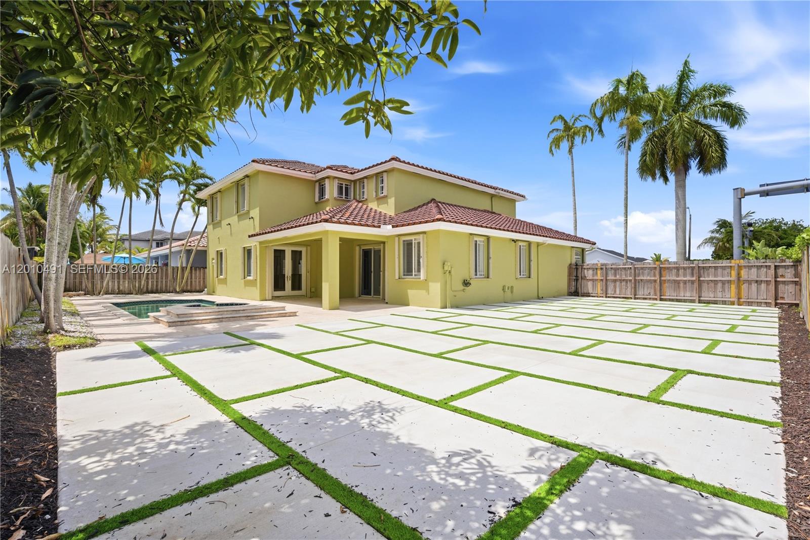 A two-story yellow house with a tiled roof, pool, and a large concrete paver patio — 15203 SW 142nd Ave, Miami FL 33177, MIAMI, FL