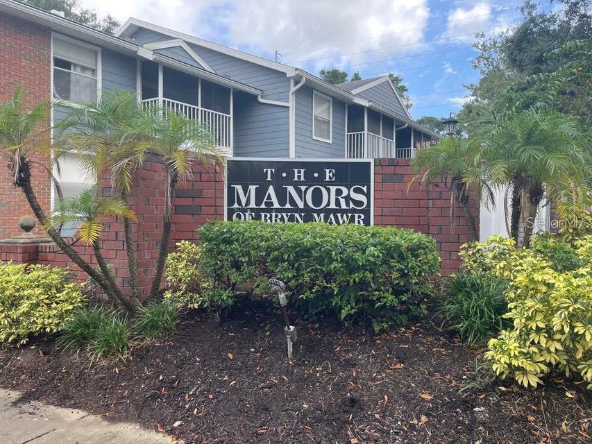A brick sign for The Manors of Bryn Mawr sits in front of a blue building — 5457 LAKE MARGARET DRIVE UNIT 19-1, ORLANDO, FL