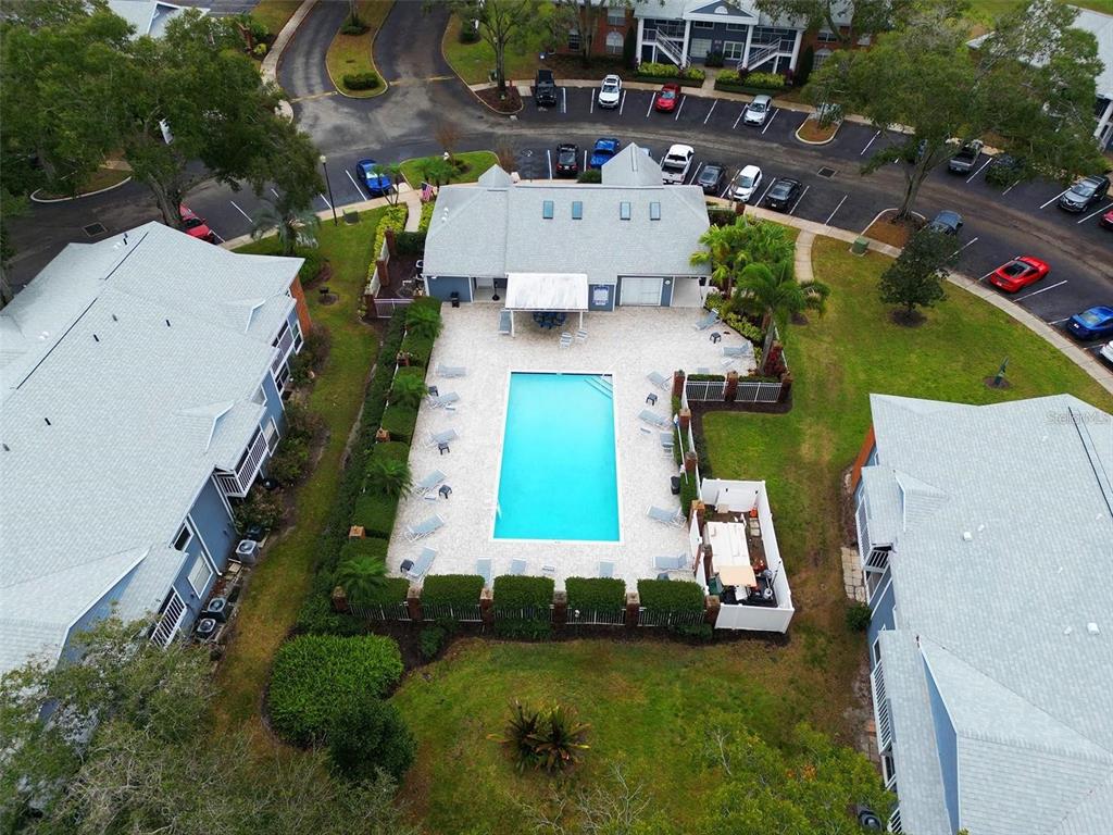 An aerial view shows a community swimming pool surrounded by a patio and apartment buildings — 5457 LAKE MARGARET DRIVE UNIT 19-1, ORLANDO, FL