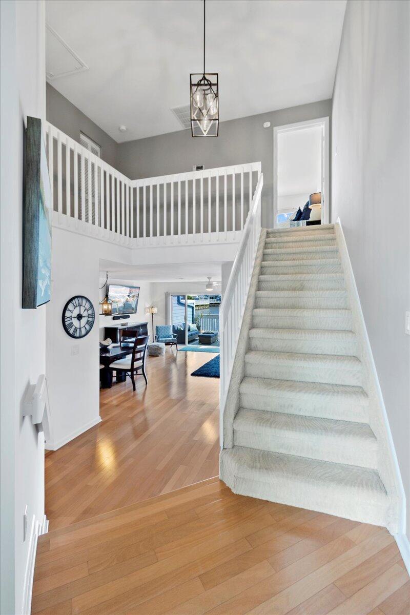 A foyer with hardwood floors leads to a carpeted staircase and an open living area — 1121 Ocean Dunes Circle, Jupiter FL 33477, JUPITER, FL