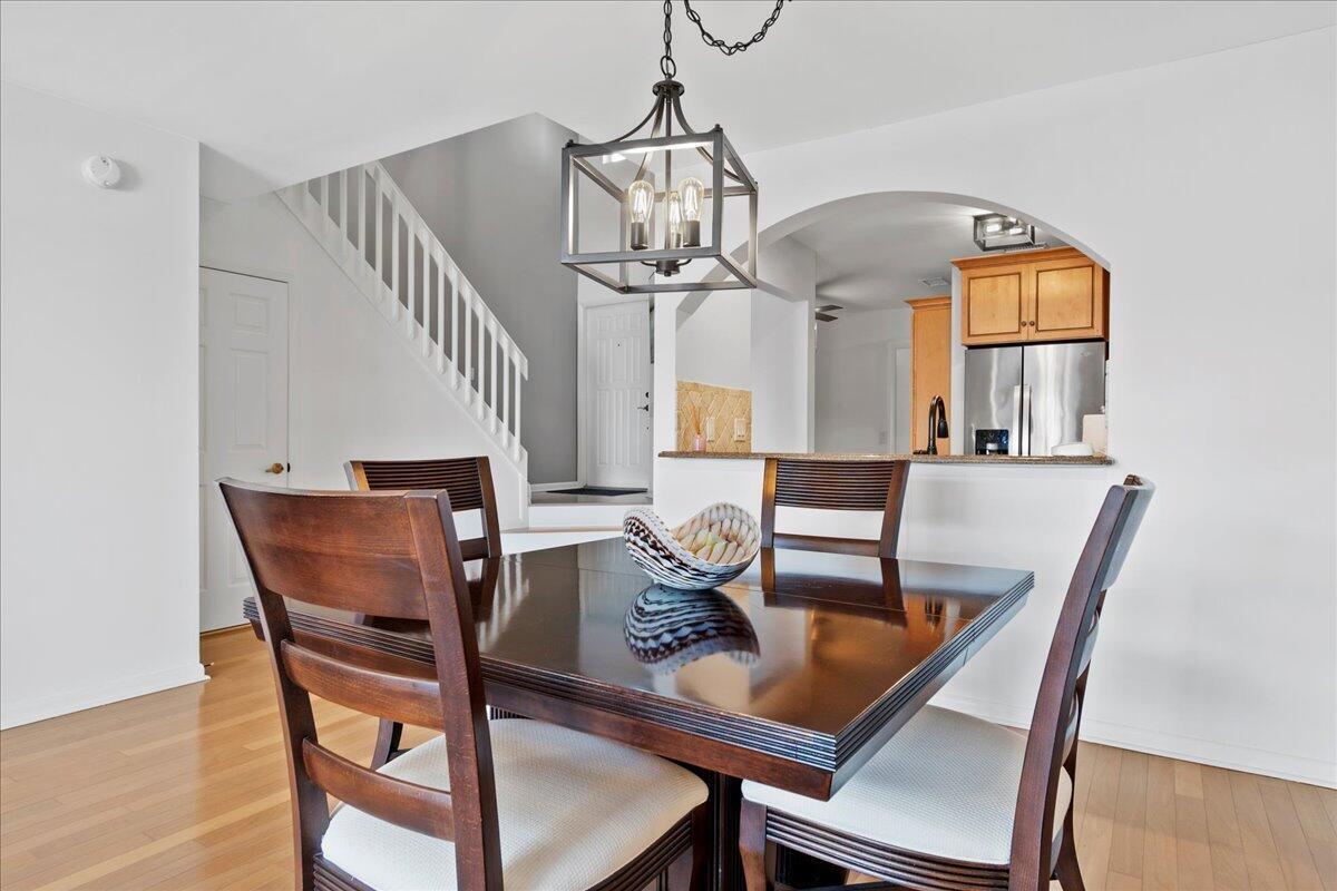 A dining area features a dark wood table, chairs, and a hanging lantern-style light fixture — 1121 Ocean Dunes Circle, Jupiter FL 33477, JUPITER, FL