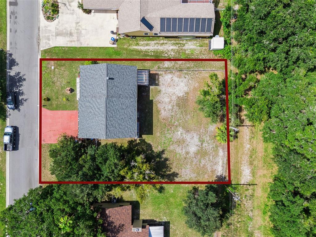 An aerial view shows a house with a large, fenced backyard and a red driveway — 1869 KINGS POINT BOULEVARD, KISSIMMEE, FL
