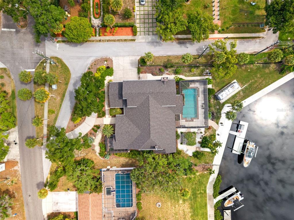 Aerial view of a waterfront house with two screened-in pools and a private boat dock — 6936 RIVER ROAD, NEW PORT RICHEY, FL
