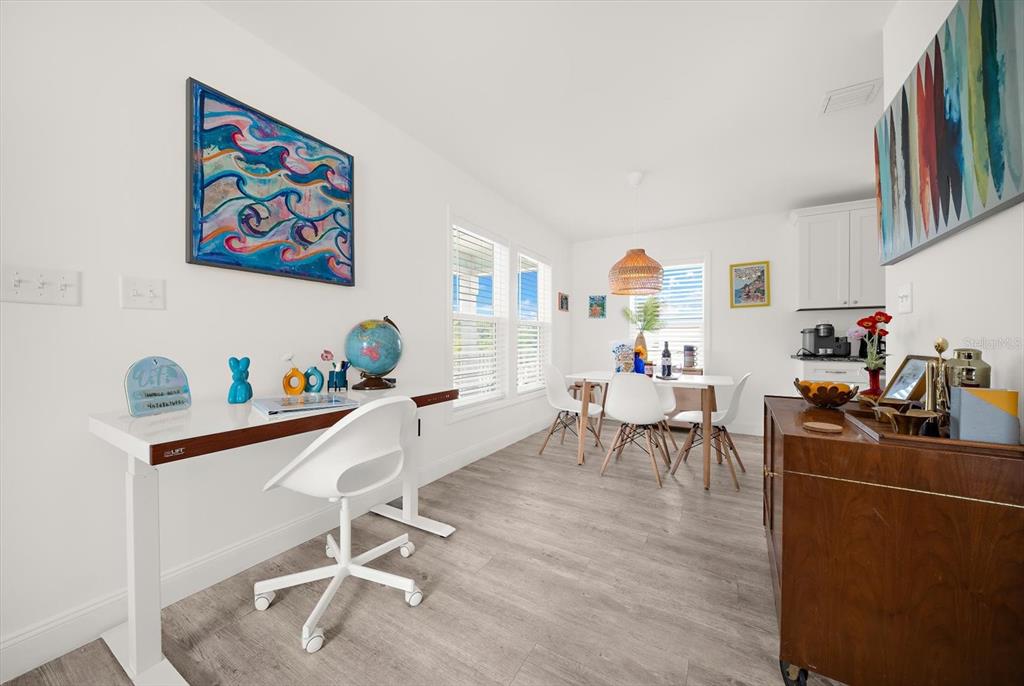 A bright room features a white desk, a dining set, and a wooden sideboard — 2375 BAHIA VISTA STREET, SARASOTA, FL