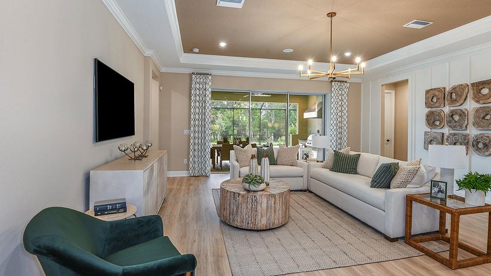 A living room features a white sofa, a circular wooden coffee table, and a green armchair — 3616 PINE PEAK LOOP, PLANT CITY, FL