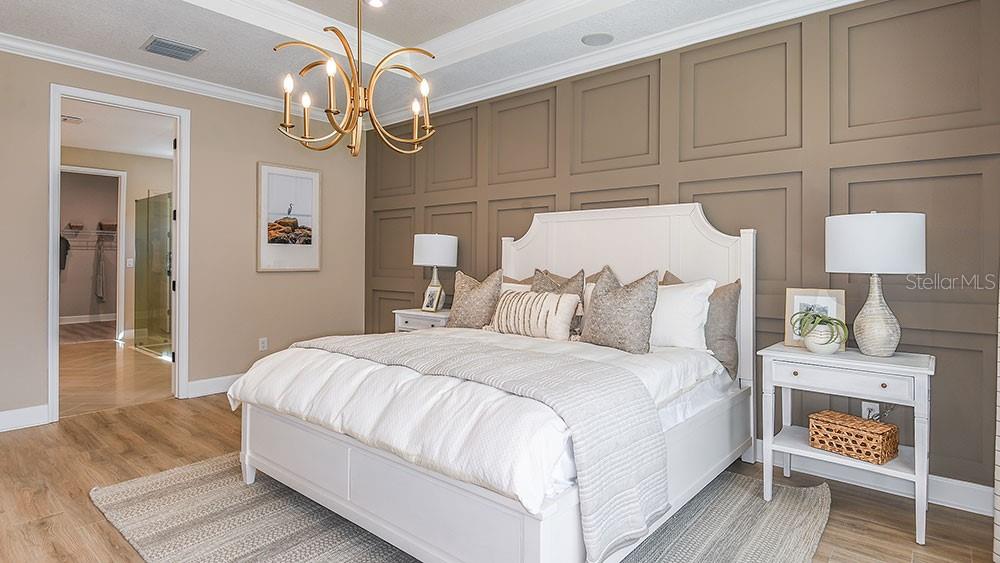 A bedroom features a white bed, a paneled accent wall, and a gold chandelier — 3616 PINE PEAK LOOP, PLANT CITY, FL