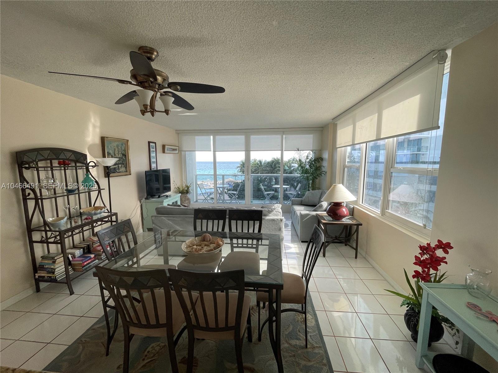 A dining and living area features tile floors, a glass table, and ocean views — 3505 S OCEAN DR # 421, Hollywood FL 33019, HOLLYWOOD, FL