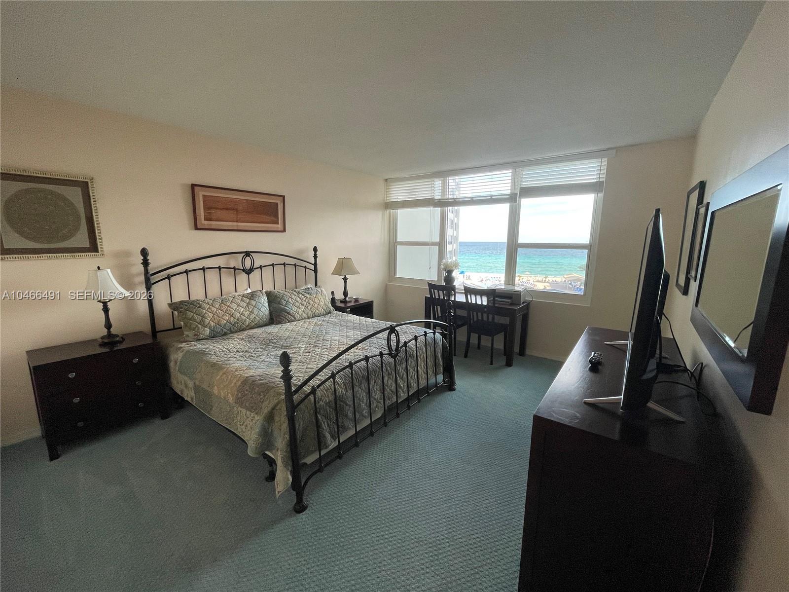 A bedroom with a metal bed frame, dark wood furniture, and a view of the ocean — 3505 S OCEAN DR # 421, Hollywood FL 33019, HOLLYWOOD, FL