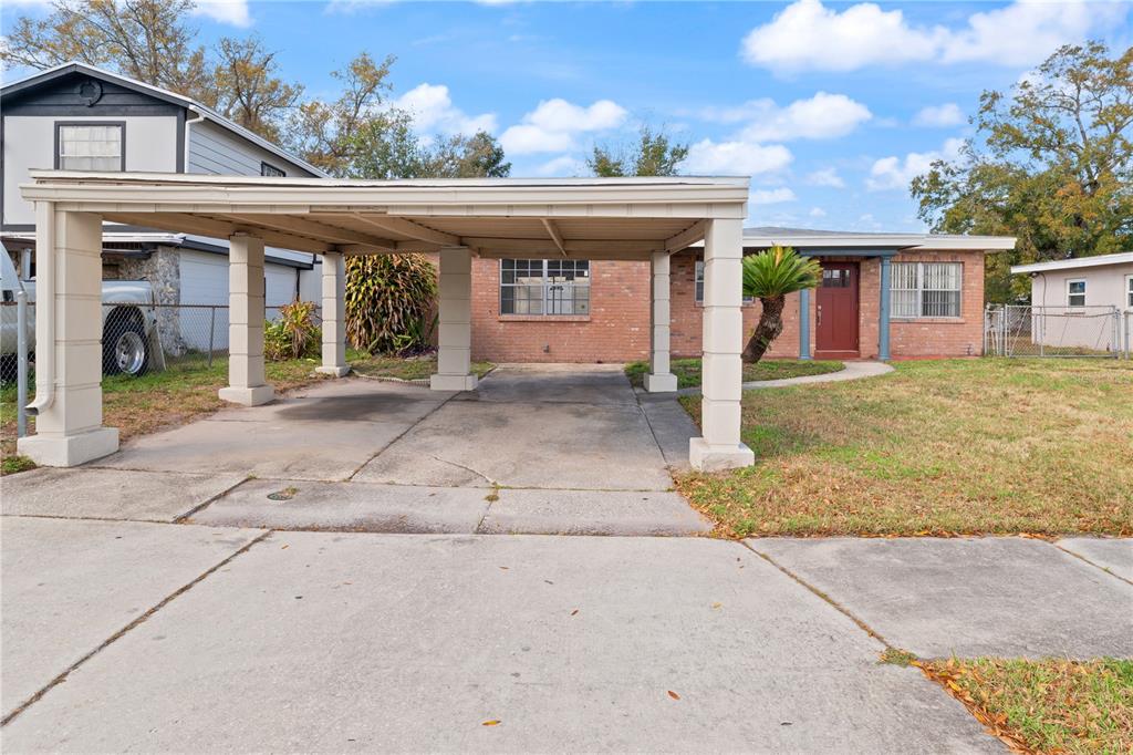 A kitchen features white cabinets, marble-patterned countertops, a white stove, and gray flooring — 6206 N LOIS AVENUE, TAMPA, FL