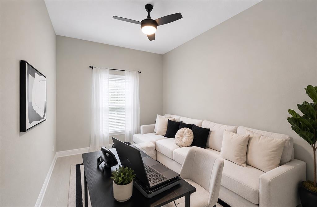 A home office features a desk, a sectional sofa, a ceiling fan, and a window — 10314 BERRYESSA AVE, RIVERVIEW, FL