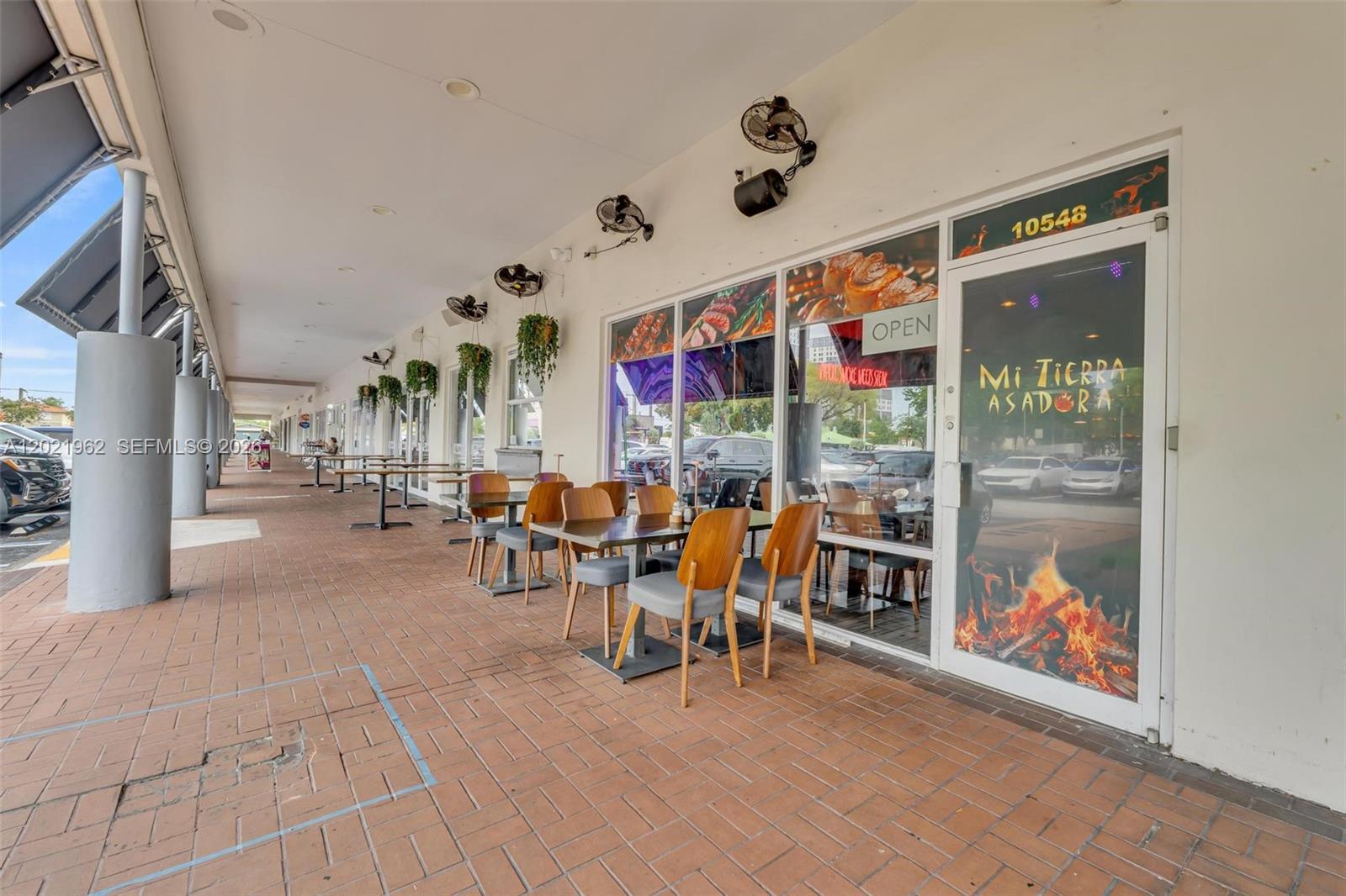 An outdoor dining area features tables and chairs in front of a restaurant storefront — 10548 SW 8, Miami FL 33174, MIAMI, FL