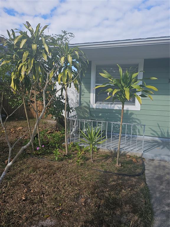 A light green house exterior features a small porch with a metal railing and landscaping — 1145 54TH AVENUE N, ST PETERSBURG, FL