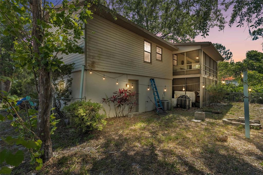 A two-story house exterior with a screened-in porch, string lights, and a backyard area — 5324 LAFAYETTE AVENUE, SEBRING, FL