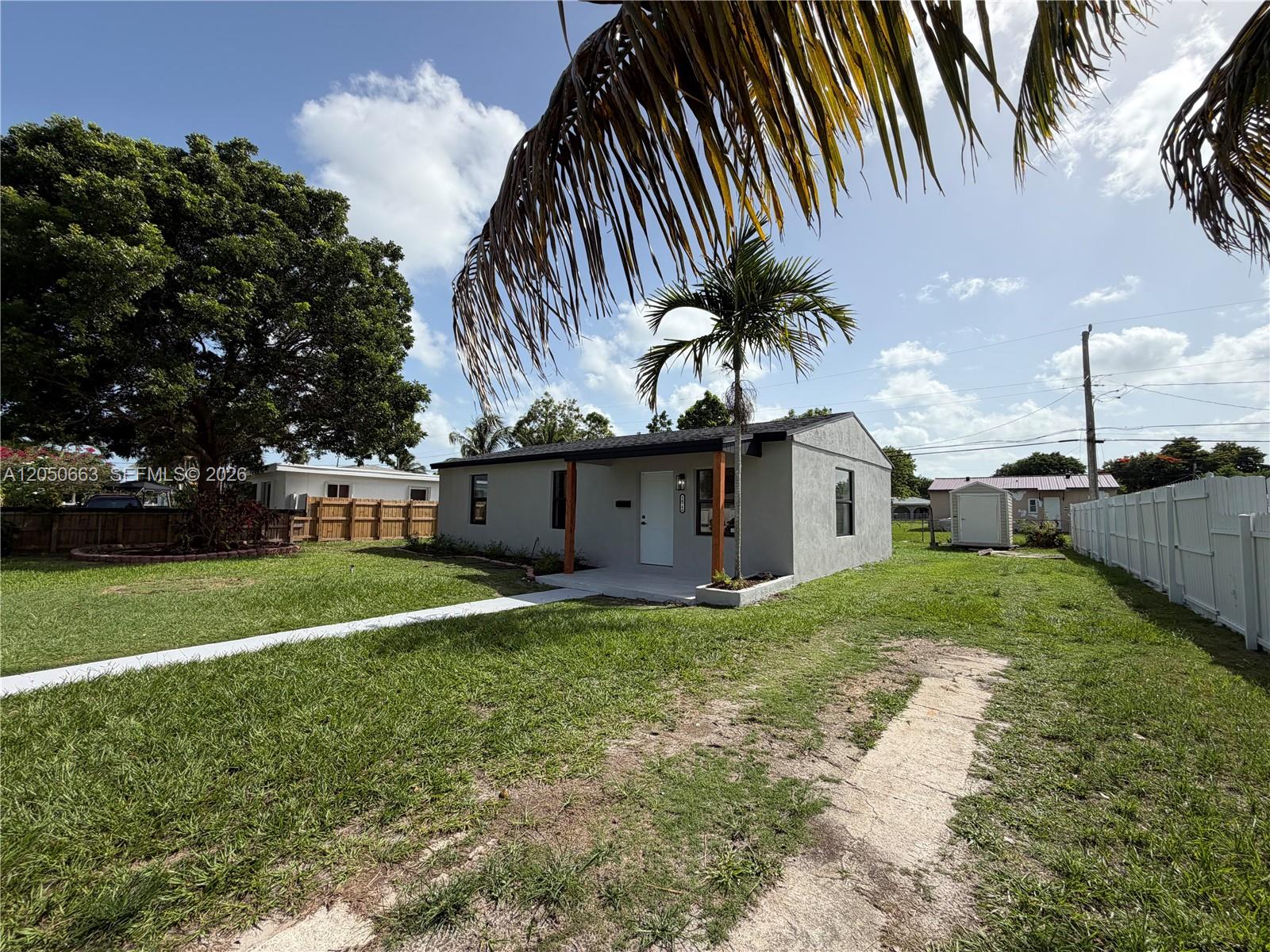 A gray, single-story house with a front porch and a palm tree in the yard — 14740 Polk St, Miami FL 33176, MIAMI, FL