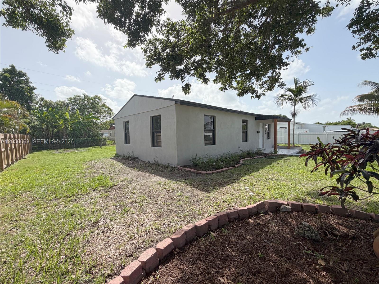 A single-story house with a light-colored exterior sits on a grassy lot with landscaping — 14740 Polk St, Miami FL 33176, MIAMI, FL