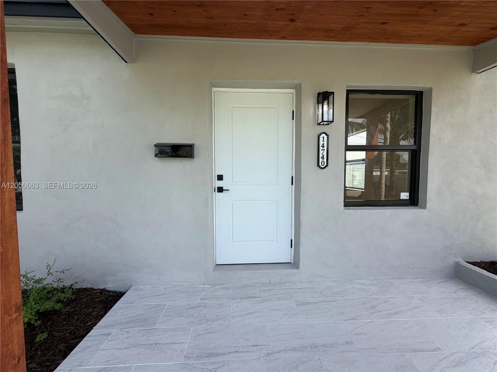 A white front door with a black mailbox and house number sits on a porch — 14740 Polk St, Miami FL 33176, MIAMI, FL