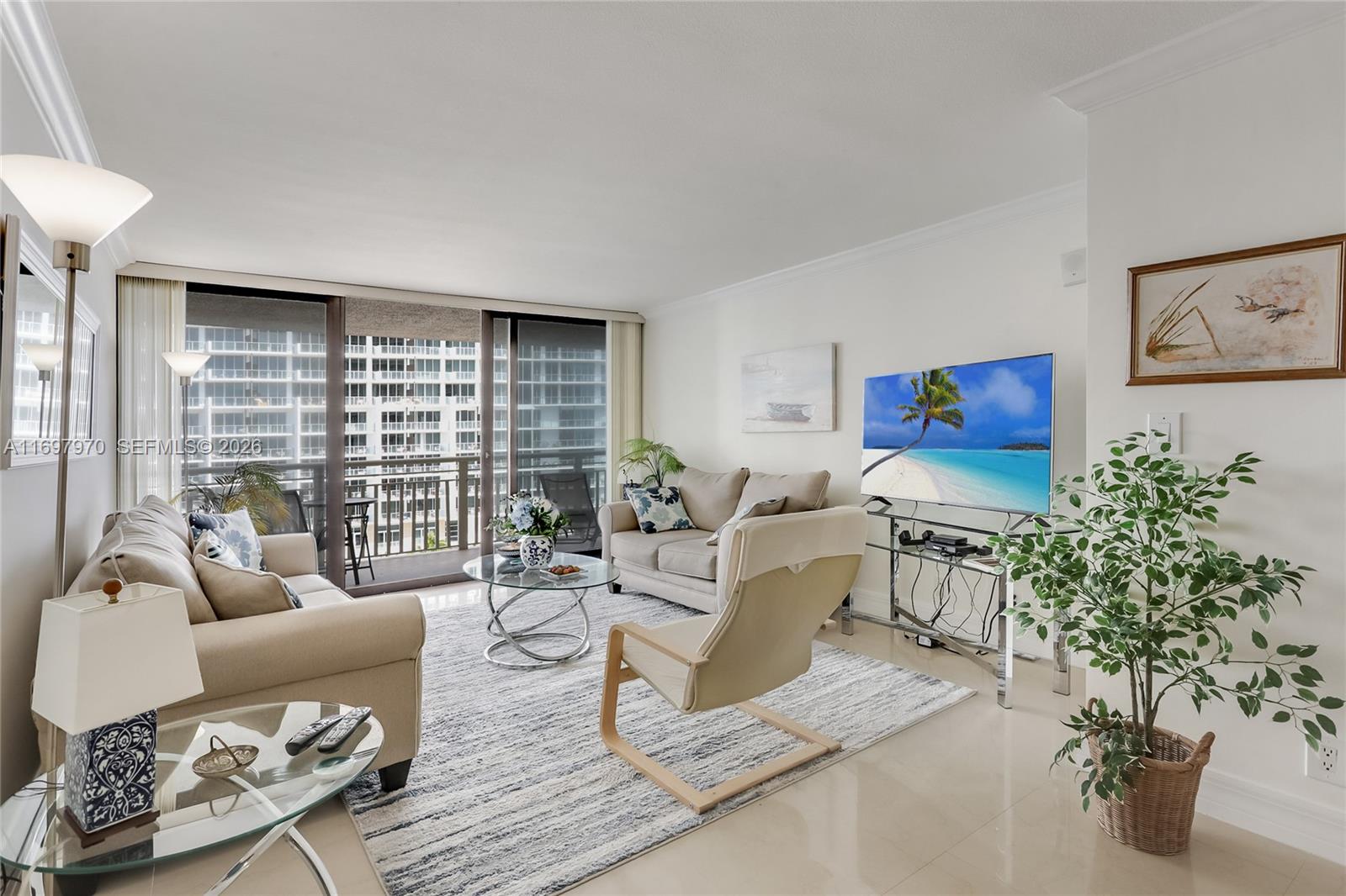 A living room features two beige sofas, a glass coffee table, and a balcony view — 3000 N Ocean Dr # 10B, Riviera Beach FL 33404, RIVIERA BEACH, FL