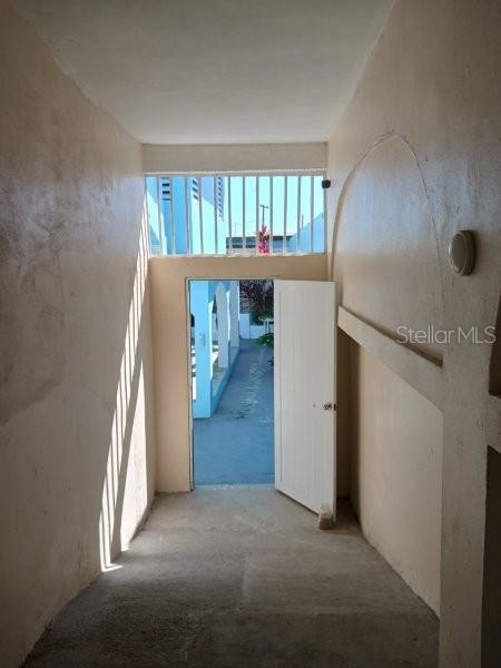 A view from a hallway through an open door toward an outdoor courtyard area — #6 CALLE 3, GUANICA, PR