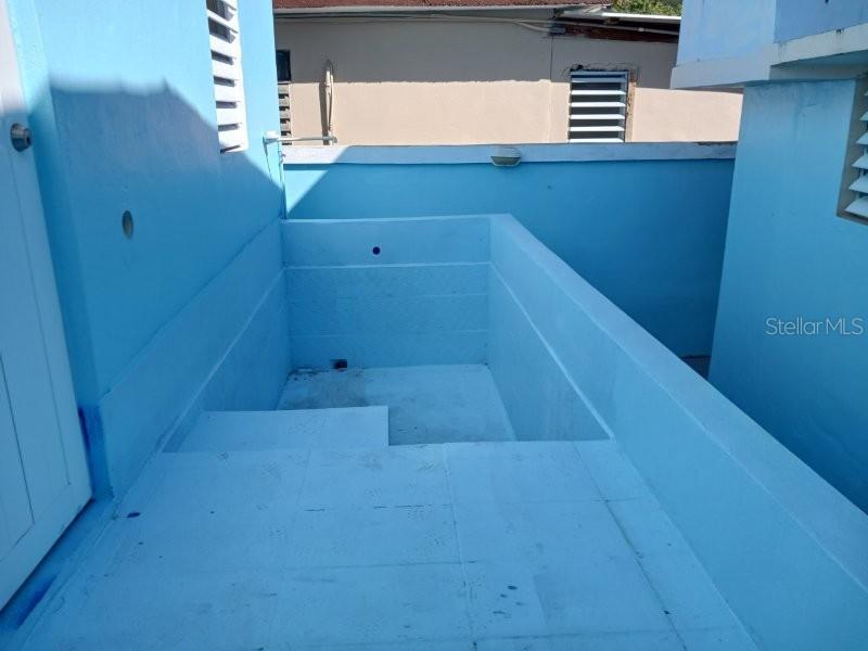 An empty, light blue painted concrete plunge pool sits on an outdoor rooftop terrace — #6 CALLE 3, GUANICA, PR