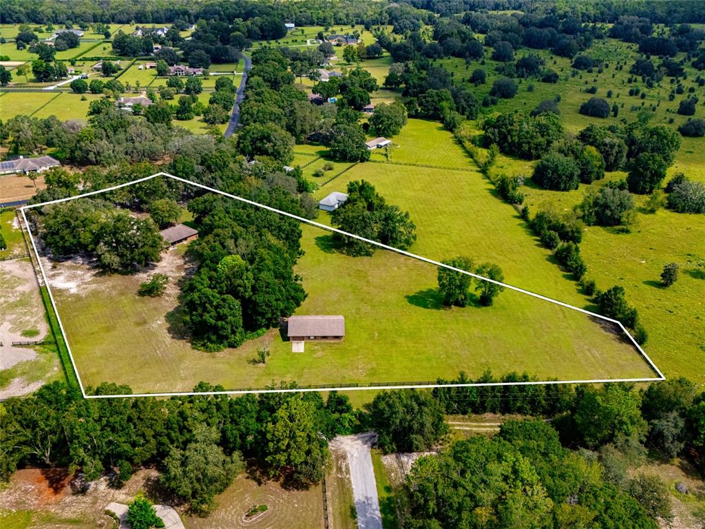 An aerial view shows a large rural property with pastures, trees, and several residential buildings — 9901 SW 67TH TERRACE, OCALA, FL