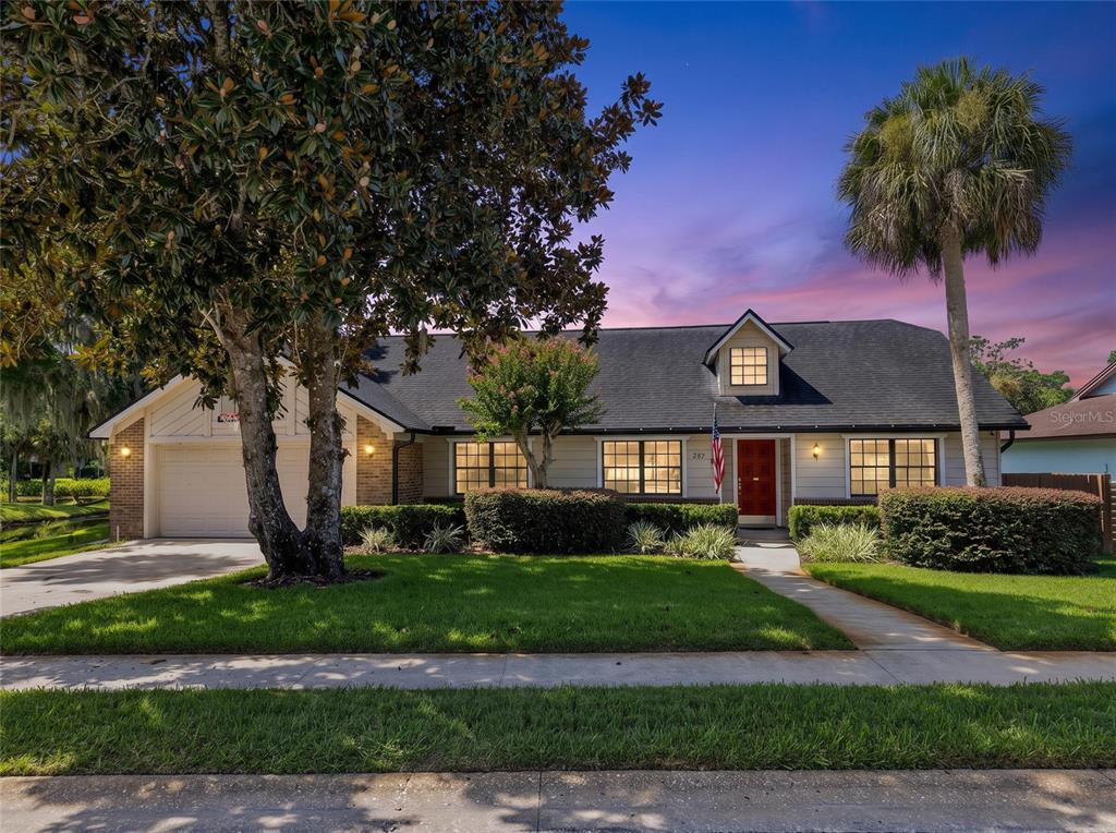 A single-story house with a red front door, a dormer window, and a large tree — 807 RIVERBEND BOULEVARD, LONGWOOD, FL