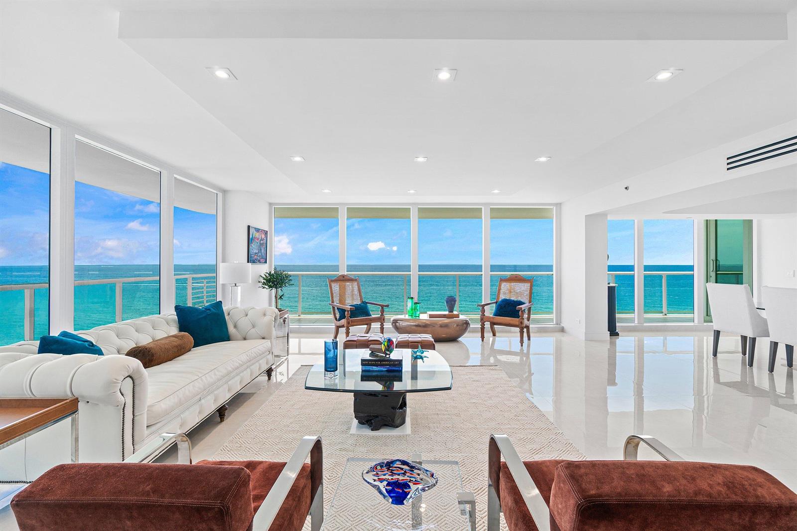 A bright living room features white tile floors, a tufted sofa, and floor-to-ceiling ocean views — 3505 S Ocean Boulevard # 12n, Highland Beach FL 33487, HIGHLAND BEACH, FL
