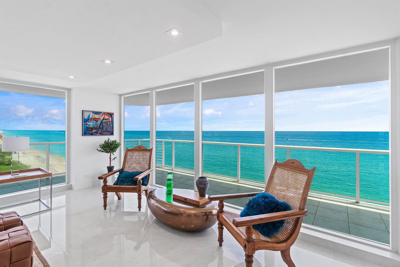 A bright living room features floor-to-ceiling windows with panoramic ocean views and tiled flooring — 3505 S Ocean Boulevard # 12n, Highland Beach FL 33487, HIGHLAND BEACH, FL