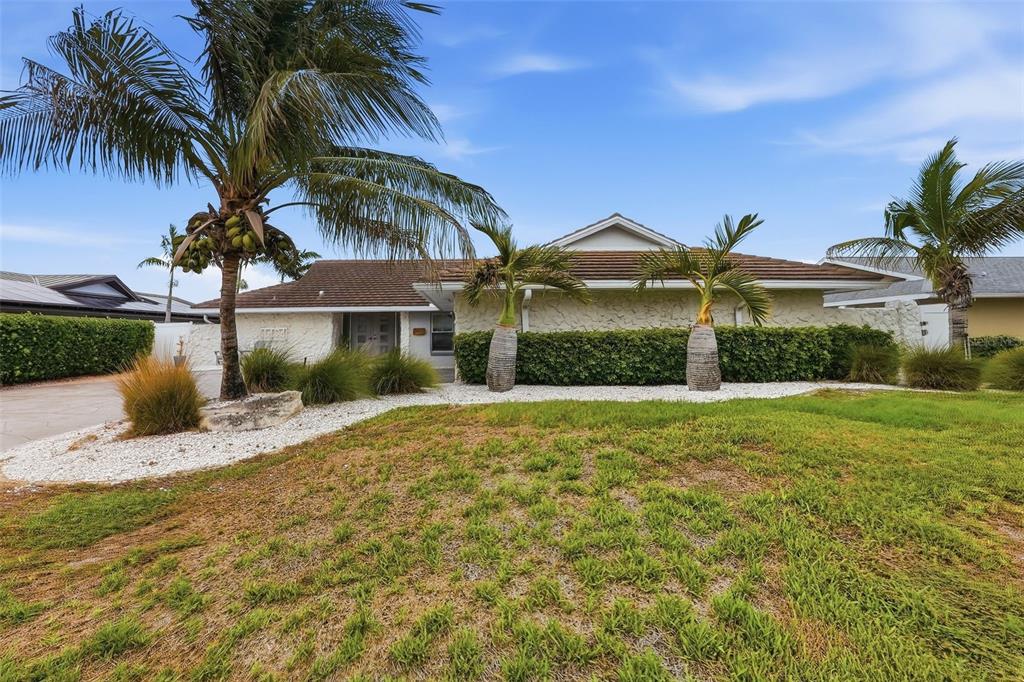 A single-story house with a textured stone facade, palm trees, and a white gravel yard — 4424 45TH STREET S, ST PETERSBURG, FL
