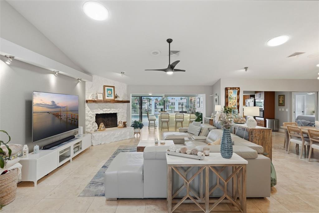 A spacious living room features a white stone fireplace, a large sectional, and tile flooring — 4424 45TH STREET S, ST PETERSBURG, FL