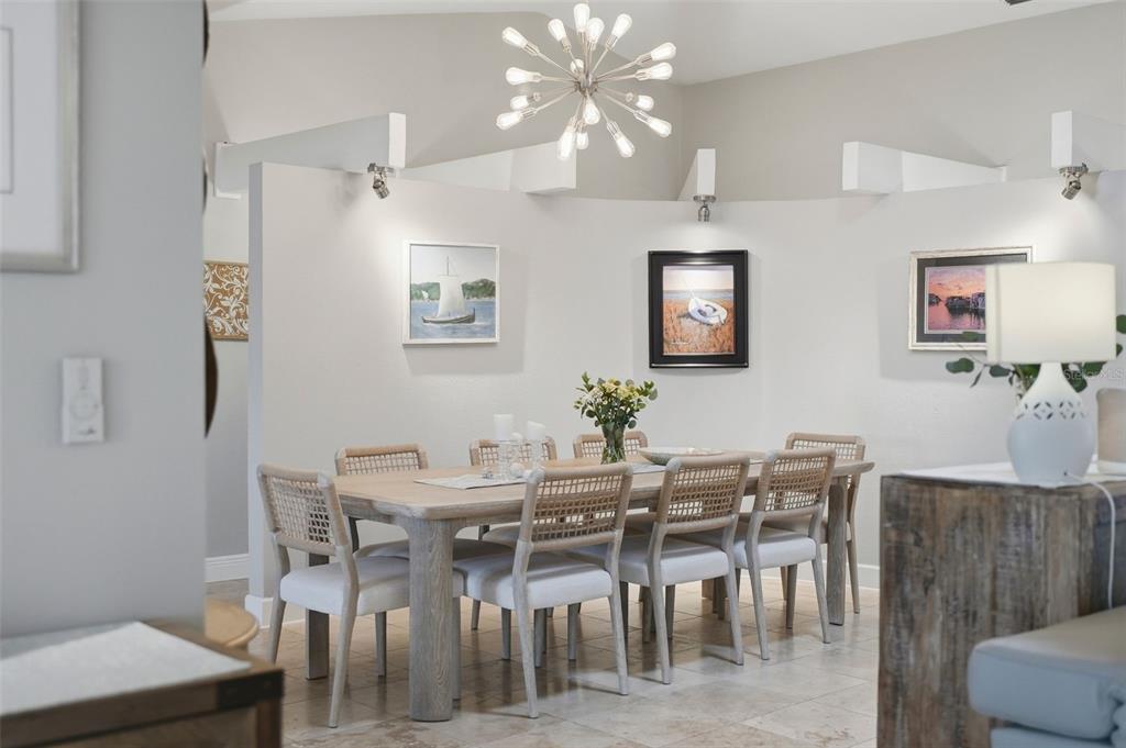 A dining room features a wooden table, six chairs, and a modern sputnik chandelier — 4424 45TH STREET S, ST PETERSBURG, FL