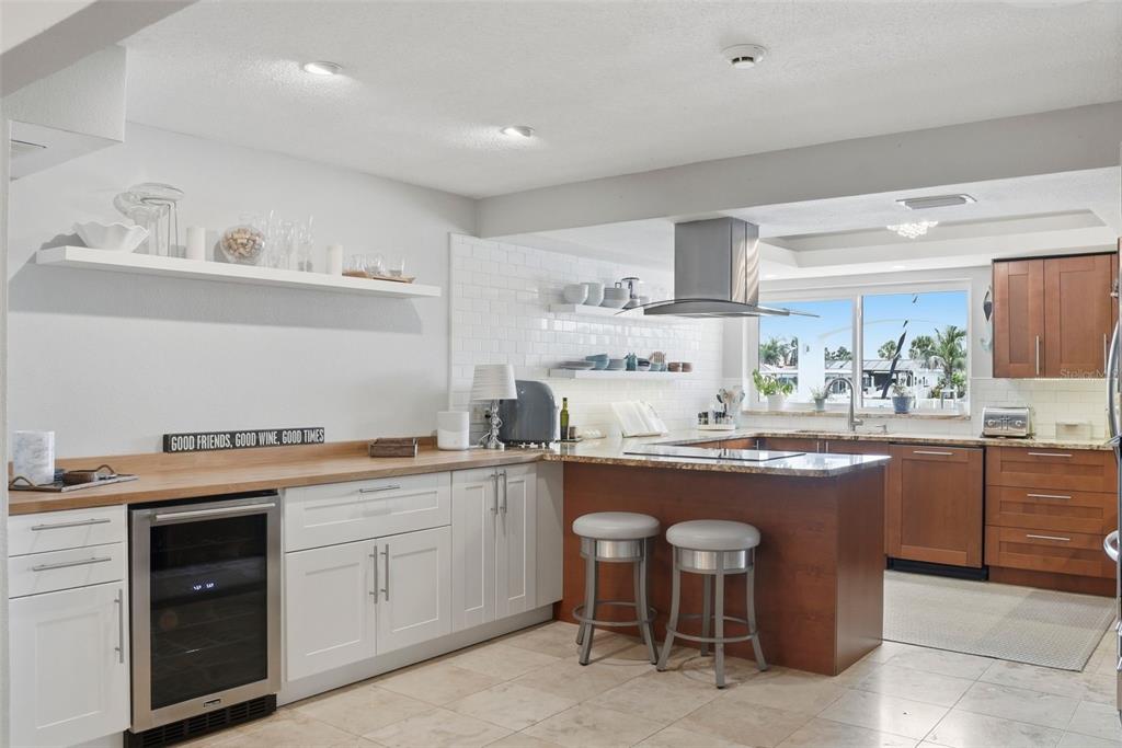 A kitchen features white and wood cabinetry, a wine cooler, and a breakfast bar island — 4424 45TH STREET S, ST PETERSBURG, FL