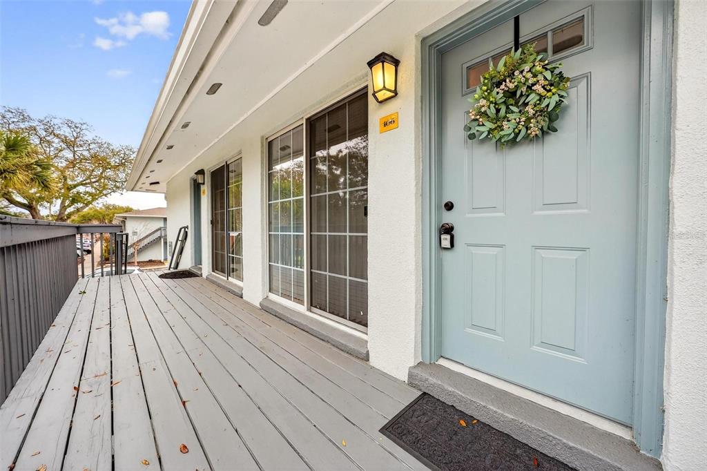 A light blue front door with a wreath and a sliding glass door open onto a deck — 4870 CONWAY ROAD UNIT 106, ORLANDO, FL