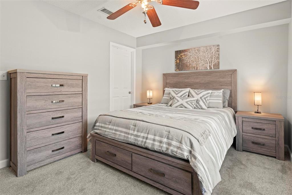 A bedroom features a wooden bed frame, matching dresser and nightstands, and gray carpet — 4870 CONWAY ROAD UNIT 106, ORLANDO, FL