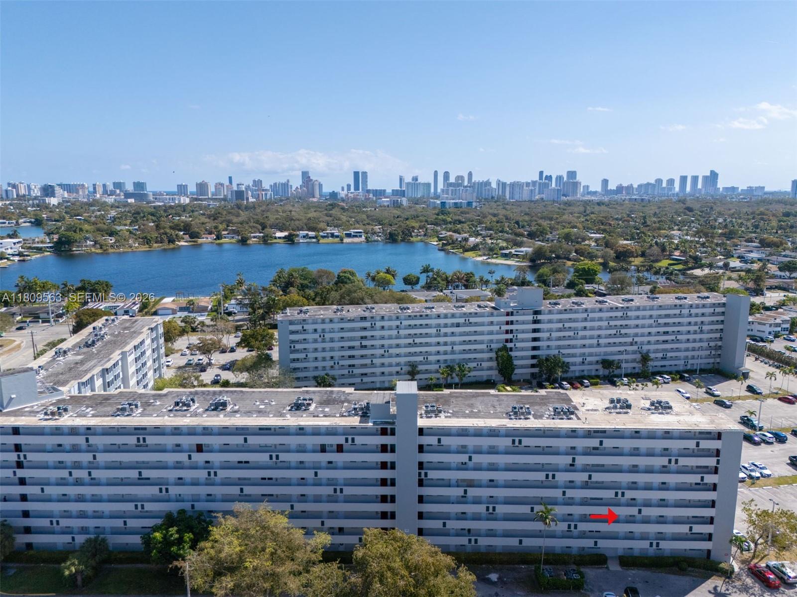 An aerial view shows two large residential apartment buildings situated near a lake and city — 1770 NE 191st St # 1, Miami FL 33179, MIAMI, FL