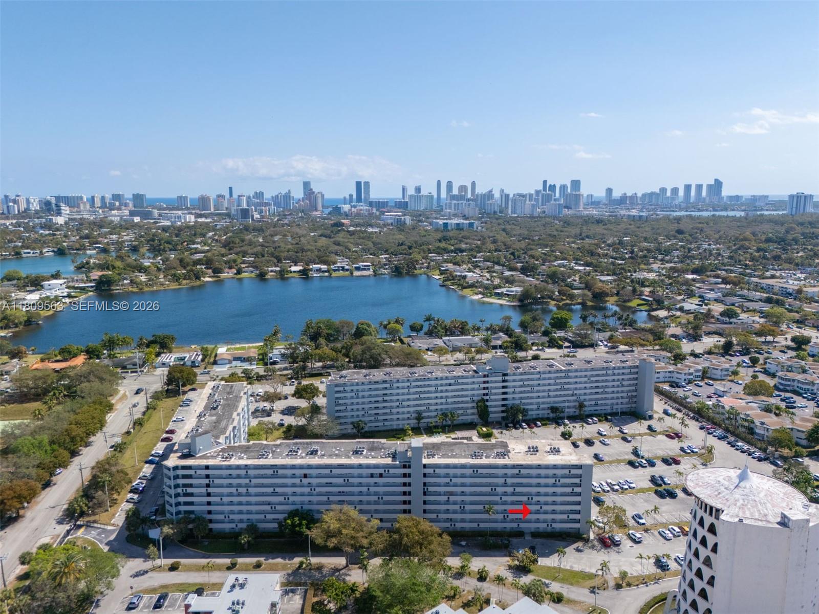 An aerial view shows two large residential apartment buildings situated near a lake — 1770 NE 191st St # 1, Miami FL 33179, MIAMI, FL