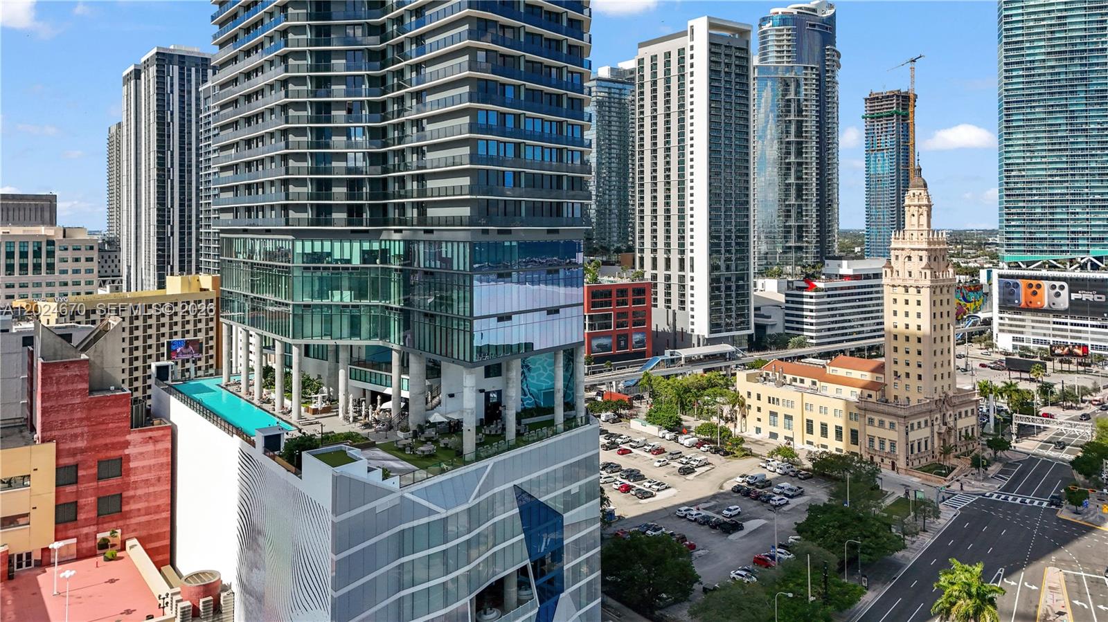 An elevated exterior view shows a modern high-rise building with a rooftop pool and terrace — 398 NE 5th St # 2310, Miami FL 33132, MIAMI, FL